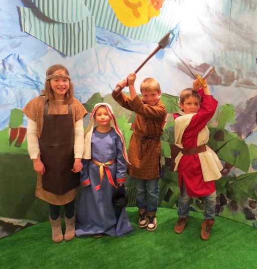 group of 4 young School children re-enacting life in the iron age