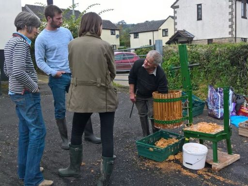 People gathering and pressing apples