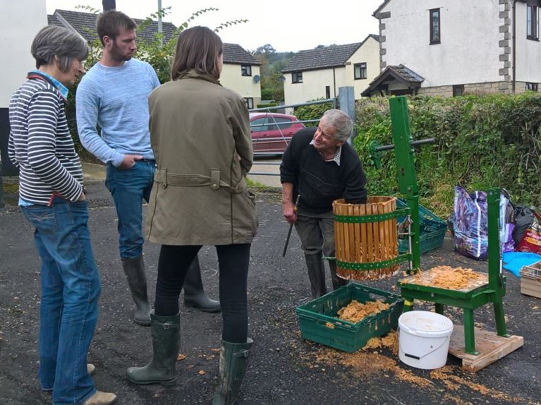 People gathering and pressing apples
