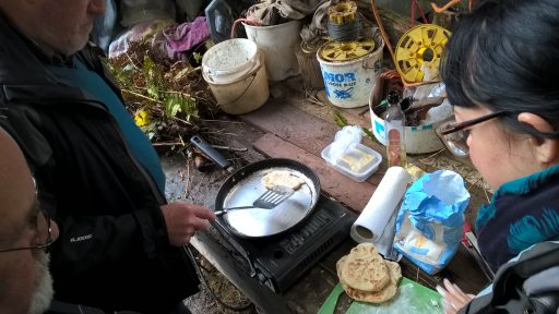 volunteers making pancakes on a camping stove