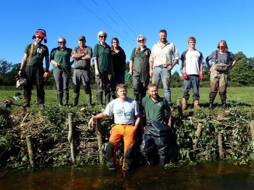 Volunteers standing in front of repaired river bank