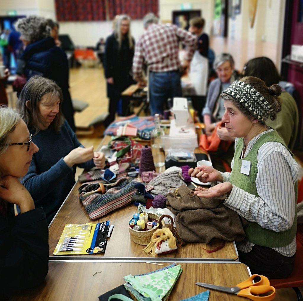 Blackdown Hills Repair Cafe, people gathered in village hall repairing items
