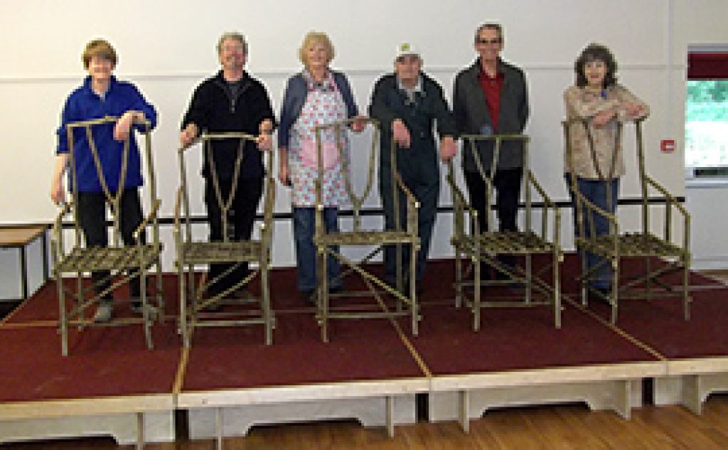 five Hedgerow chairs with people stood behind on a stage