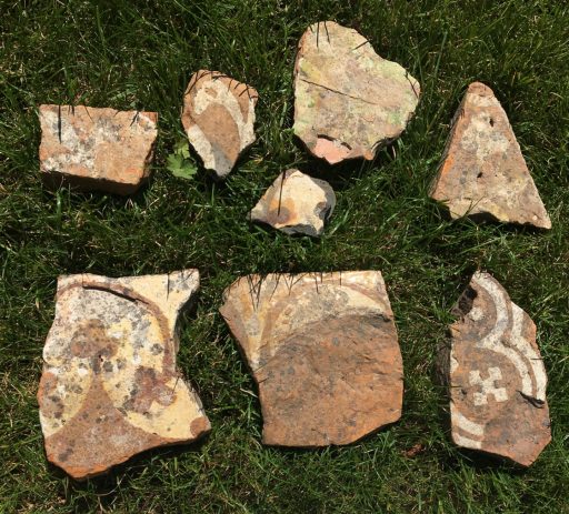 Floor tile fragments on which you can make out some of the original designs