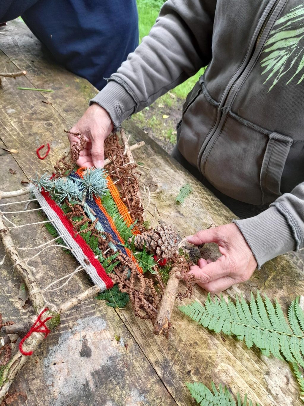 someone holding a part-finished nature loom