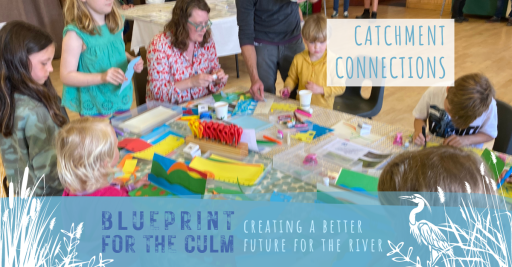 woman and 6 children sat around a table doing art