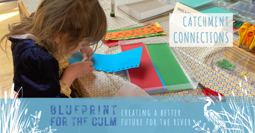 child using a paper press to cut out blue star shapes