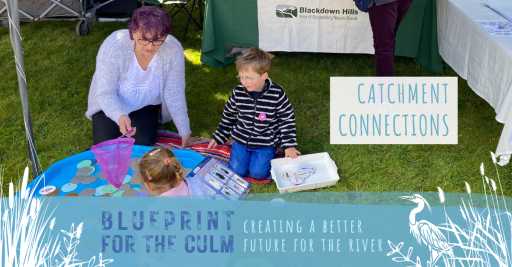 lady with two young children playing a fish game in a blue tray