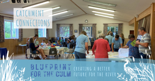group of adults and children looking at maps in a village hall