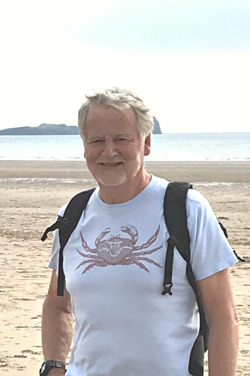 Bruce Payne stood on a beach wearing a crab t-shirt