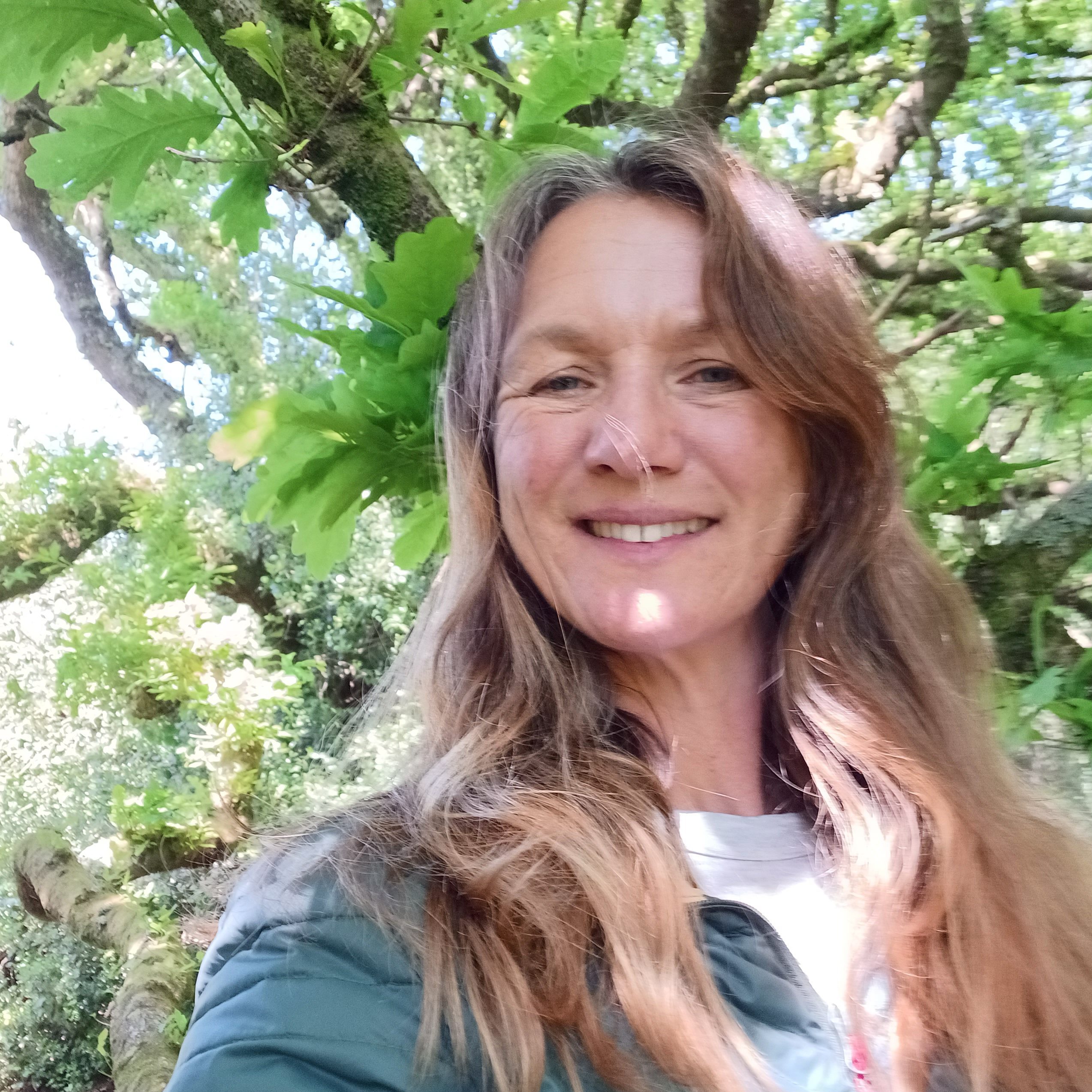 Jane Robertson standing under a tree in the dappled sunshine