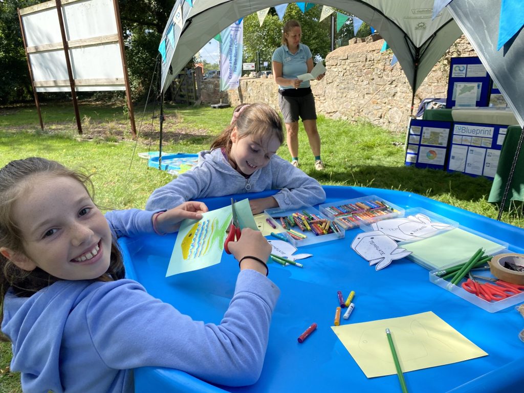Children taking part in craft activities colouring in fish templates in bright colours
